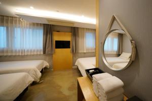 a hotel room with two beds and a mirror at Hotel DADA Insadong in Seoul