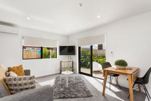 a living room with a couch and a table at Charming Sunny Warm 10 Mins CBD Book Now in Christchurch