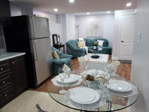 Luxurious 1BR-1BA Apartment Bright Spacious with free parking في برامبتون: مطبخ وغرفة معيشة مع طاولة زجاجية