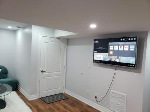 Habitación con TV de pantalla plana en la pared en Luxurious 1BR-1BA Apartment Bright Spacious with free parking en Brampton