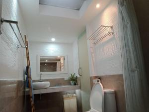 y baño con aseo, lavabo y espejo. en Punyan Poh Villas, en Denpasar