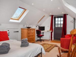 a bedroom with a bed and a desk and a window at Old Chimneys Studio in Lewes