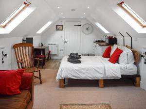 a bedroom with a bed and a chair and a clock at Old Chimneys Studio in Lewes