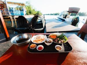 ein Tablett mit Essen auf einem Tisch neben einem Boot in der Unterkunft homestay 9 sông 