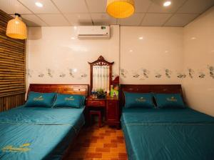 1 Schlafzimmer mit 2 Betten, einem Tisch und einem Spiegel in der Unterkunft homestay 9 sông 