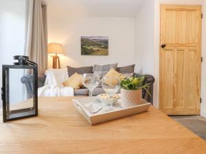 una sala de estar con una mesa con dos copas de vino. en The Wonky Burrow, en Bowness-on-Windermere