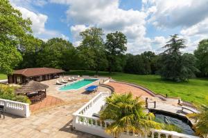 - une vue aérienne sur une piscine avec un pavillon dans l'établissement Large Villa Mansion With Pool House & Tennis Court, à Potters Bar