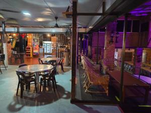 un ristorante con tavoli, sedie e luci viola di Heritage House Windcave Bar & Stay a Bau