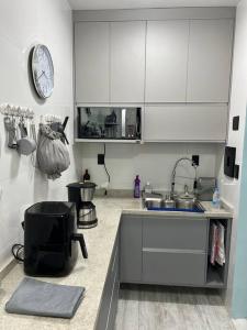 una cocina con fregadero y un reloj en la pared en Apartamento super aconchegante. en Teresópolis