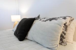 a pile of pillows on a bed in a room at Affordable Apartment Hagley Park Super Fast Wifi in Christchurch