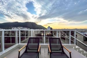 two chairs on a balcony with a view of the mountains at Nosso Apê 915: Central | Academia | Piscina NA0714 in Juiz de Fora