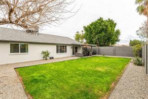 a house with a green lawn in front of it at Gorgeous 4BR/2BA Home in North Central Phoenix in Phoenix