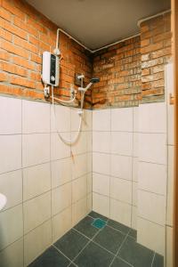 bagno con doccia in un muro di mattoni di Heritage House Windcave Bar & Stay a Bau