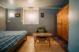 una camera con letto, sedia e tavolo di Heritage House Windcave Bar & Stay a Bau