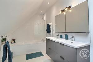 un bagno bianco con lavandino e vasca di Le colombier a Dinan Altre 21 foto