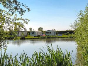 a view of a lake with houses in the background at Kingfisher - Uk41950 in Louth