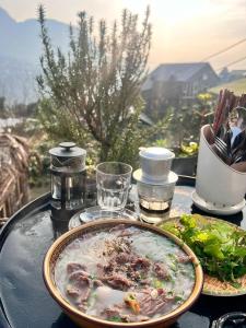 einen Tisch mit einem Teller Essen auf dem Tisch in der Unterkunft Plum Eco House in Sa Pa