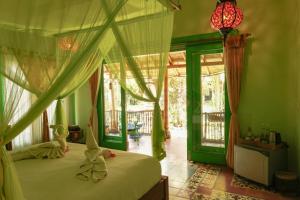 a bedroom with a bed with a canopy at Bali Bohemia Huts in Ubud