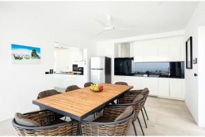 una sala da pranzo con tavolo e sedie in legno di Luxury 5 Bedroom Modern Villa! KBR17 a Nathon Bay