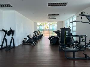 een fitnessruimte met loopbanden en crosstrainers in een kamer bij 9 pax @ 3 rooms TT3Soho Kuching in Kuching