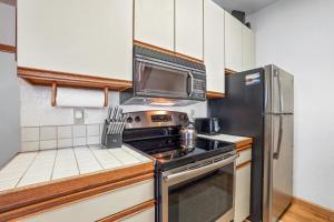 a kitchen with a stove and a microwave at Sierra Cabin Condo – Sun Meadows 1 BedroomLoft condo in Kirkwood