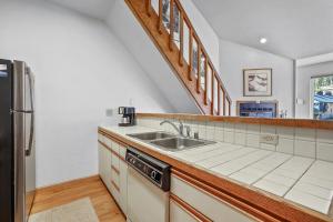 a kitchen with a sink and a refrigerator at Sierra Cabin Condo – Sun Meadows 1 BedroomLoft condo in Kirkwood +18 photos