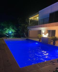 ein Schwimmbad in der Nacht mit einem Haus in der Unterkunft CASA CAMPESTRE A POCOS MINUTOS DE CARTAGENA in Santa Rosa