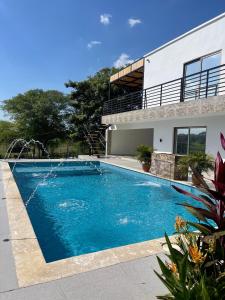 a swimming pool in front of a house at CASA CAMPESTRE A POCOS MINUTOS DE CARTAGENA in Santa Rosa