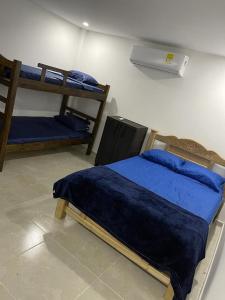 a bedroom with two bunk beds and a fan at CASA CAMPESTRE A POCOS MINUTOS DE CARTAGENA in Santa Rosa