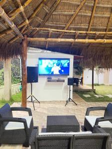 a large screen tv in a pavilion with chairs at CASA CAMPESTRE A POCOS MINUTOS DE CARTAGENA in Santa Rosa