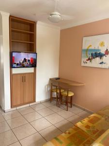 a room with a table and a tv on the wall at Diroma Fiori Hotel in Caldas Novas