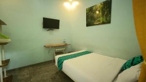 Cette petite chambre comprend un lit et une télévision. dans l'établissement Kalimaya Residence Syariah 1 by Cocotel, à Brumbung
