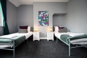Spacious | 3BR | WiFi في نيوبورت: سريرين توأم في غرفة مع لوحة على الحائط