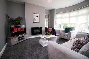 uma sala de estar com uma televisão e um sofá em Spacious | 3BR | WiFi em Newport