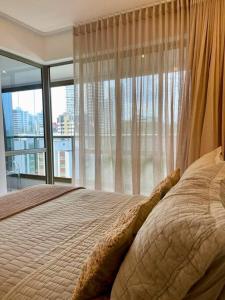 サルバドールにあるBeach Class - Barra Ondina SSAのベッドと大きな窓のある寝室