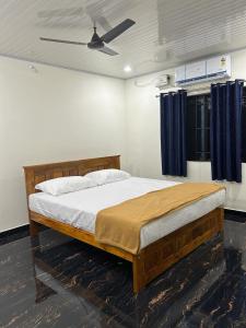 1 dormitorio con cama de madera y cortinas azules en Yashovana Nature Stay Gokarna, en Gokarna