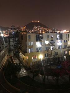 a view of a building at night with lights at condominio la muralla in Lima