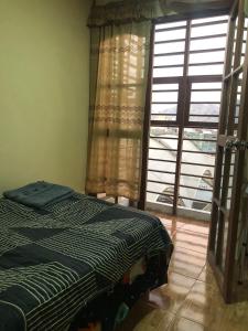 - une chambre avec un lit et une grande fenêtre dans l'établissement condominio la muralla, à Lima