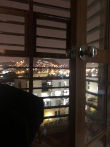 - une vue sur la ville depuis une fenêtre la nuit dans l'établissement condominio la muralla, à Lima