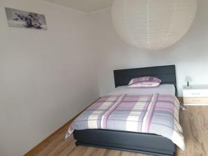 a bedroom with a bed with a striped comforter at Shalom in Goddert +1 photo