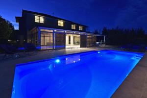 ein Schwimmbad vor einem Haus in der Nacht in der Unterkunft HOT HOT Spoil someone special at this luxe Hunter Valley Estate - stunning luxury in super central location in Nulkaba