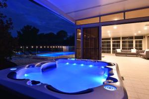 eine Whirlpool-Badewanne im Hinterhof eines Hauses in der Unterkunft HOT HOT Spoil someone special at this luxe Hunter Valley Estate - stunning luxury in super central location in Nulkaba