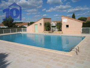 una grande piscina di fronte a un edificio di Maison Vendres, 2 pièces, 6 personnes - FR-1-781-1 a Vendres