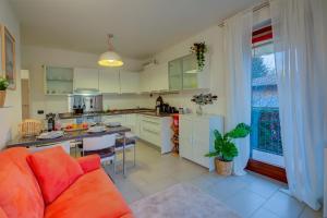 a kitchen and living room with a couch and a table at Lenni Apart Swimming Pool and lake - Happy Rentals in Leggiuno