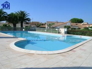 uma grande piscina com água azul em Appartement Valras-Plage, 3 pièces, 4 personnes - FR-1-781-12 em Valras-Plage