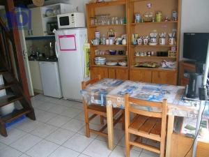 uma cozinha com uma mesa com cadeiras e um frigorífico em Appartement Valras-Plage, 3 pièces, 4 personnes - FR-1-781-12 em Valras-Plage