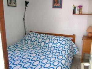 uma cama com um edredão azul e branco num quarto em Appartement Valras-Plage, 3 pièces, 4 personnes - FR-1-781-12 em Valras-Plage