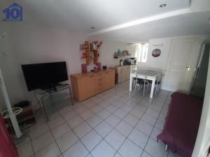 een woonkamer met een flatscreen-tv en een keuken bij Maison Valras-Plage, 2 pièces, 6 personnes - FR-1-781-18 in Valras-Plage