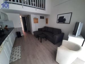 ein Wohnzimmer mit einem Sofa und einem TV in der Unterkunft Maison Valras-Plage, 4 pièces, 6 personnes - FR-1-781-16 in Valras-Plage