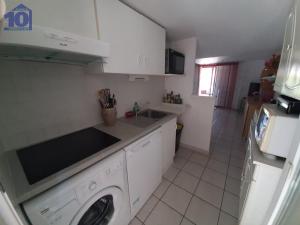 een keuken met een wasmachine en een wastafel bij Maison Valras-Plage, 2 pièces, 6 personnes - FR-1-781-18 in Valras-Plage